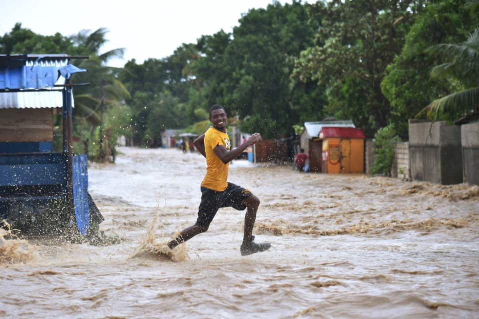  A man runs to cross the overflowing river Rouyonne in Haiti where Hurricane Matthew has already caused devestation