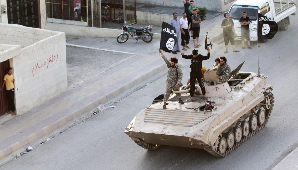  Militant Islamist fighters take part in a military parade along the streets of northern Raqqa province June 30, 2014 before their territorial losses