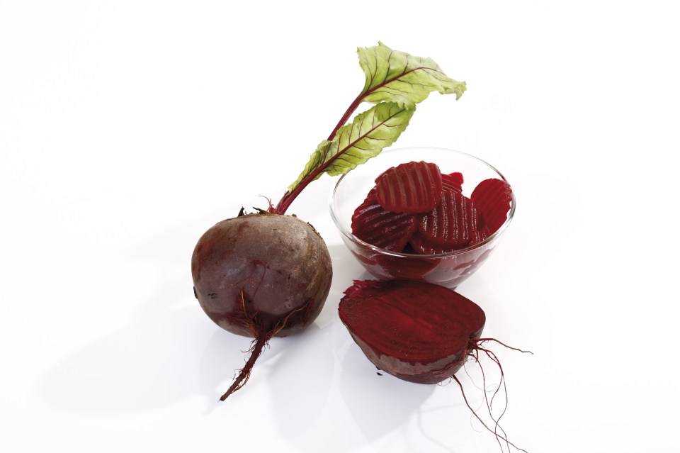 Whole and halved beetroot on white background, close-up