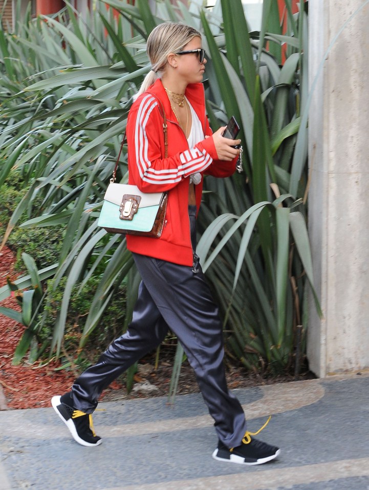 She teamed her red tracksuit top with jogging bottoms