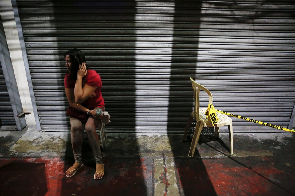 A woman cries after her husband was shot dead by unidentified gunmen riding motorcycles in Manila