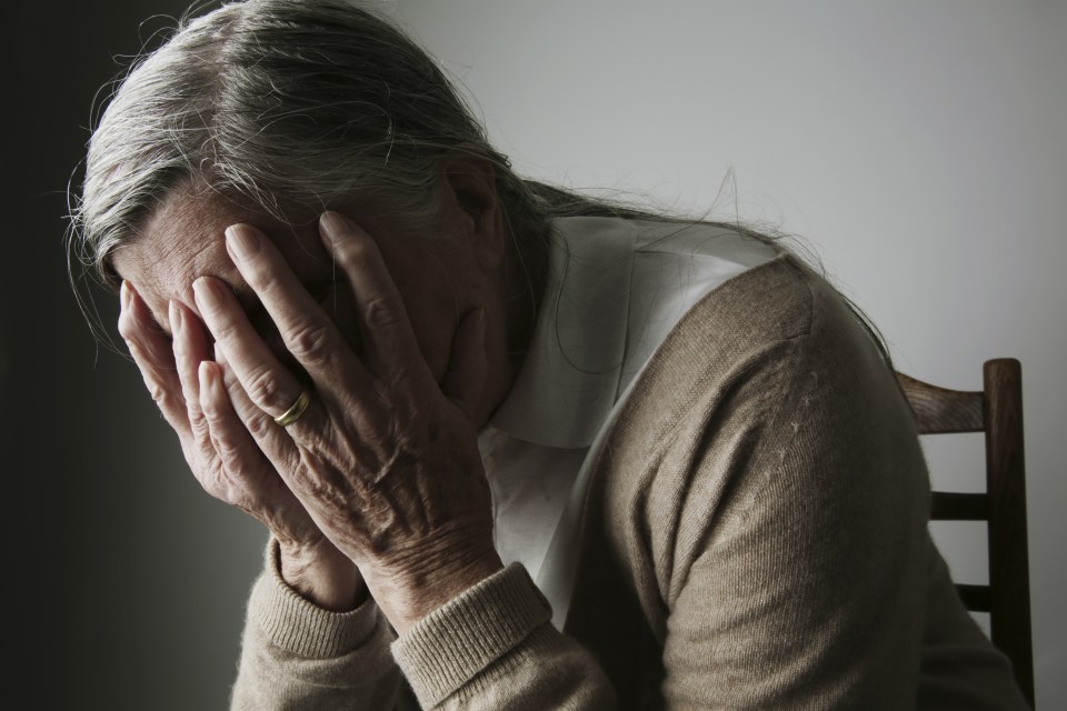 Senior woman covering face with her hands