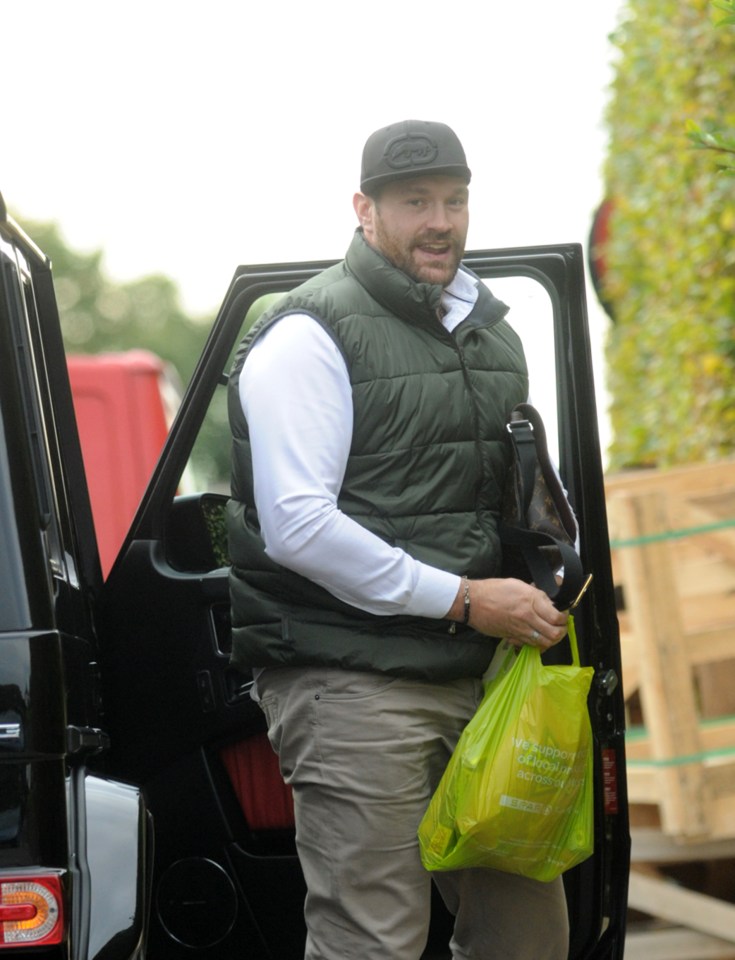  Tyson Fury holds a plastic bag filled with snacks after arriving home