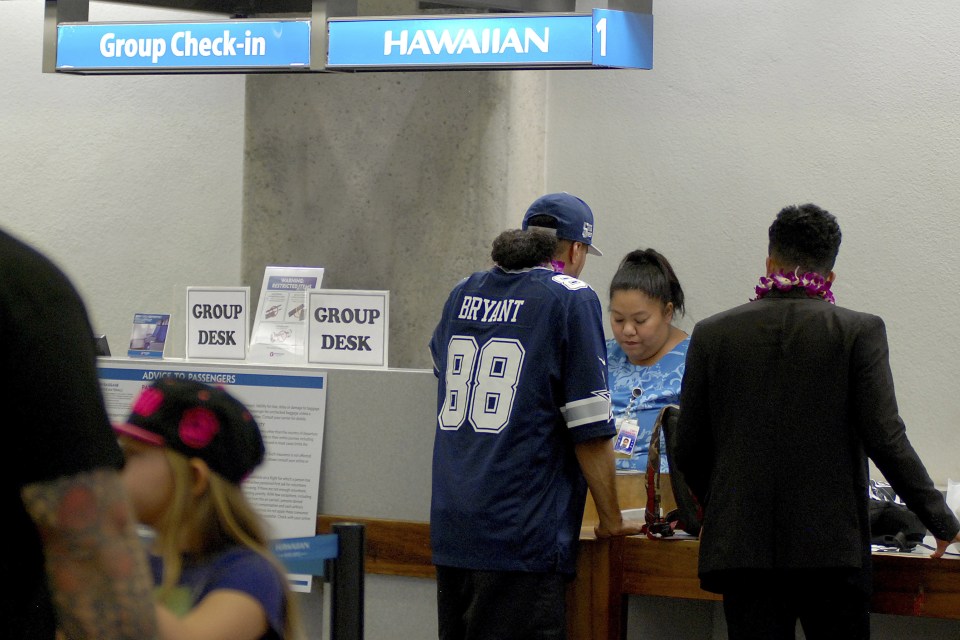 Passengers stand at a Hawaiian Airlines check-in counter before a flight to Pago Pago, American Samoa at Honolulu International Airport in Honolulu