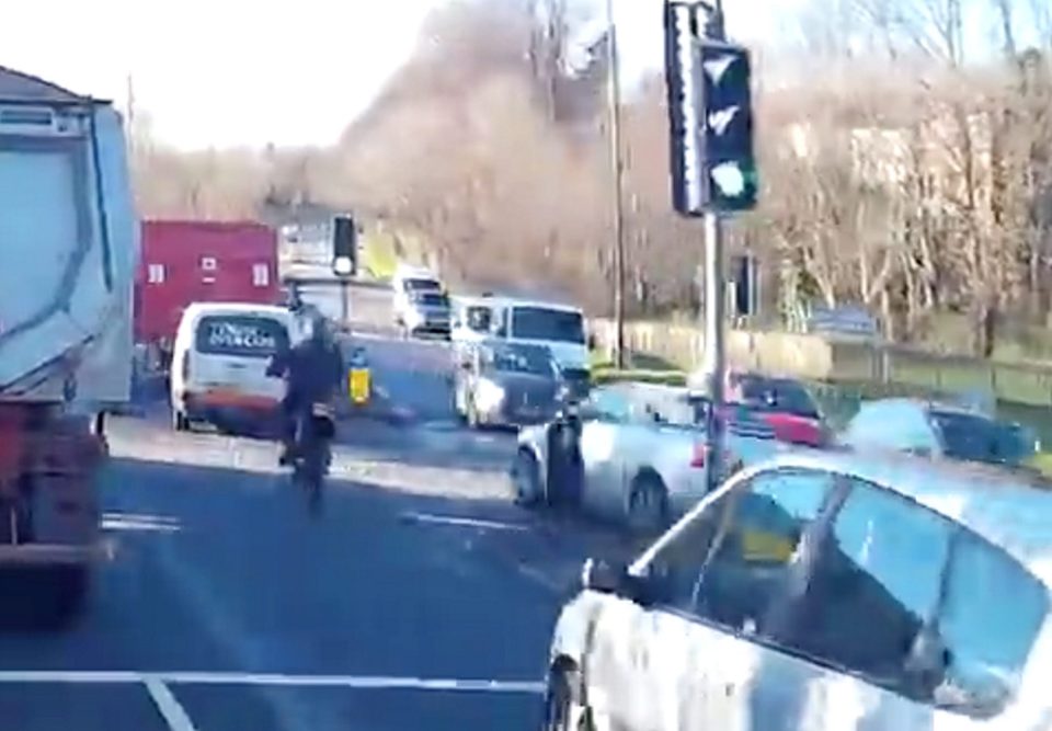  The motorbike rider can be seen going through the traffic when the car crosses to the wrong side of the road