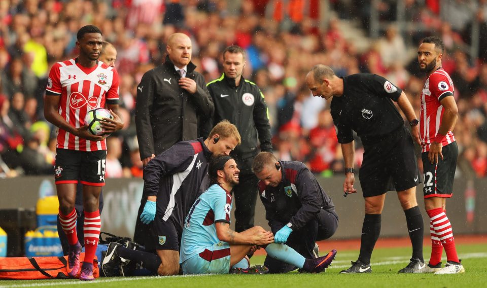  Dean attends to George Boyd as the Burnley man goes down injured