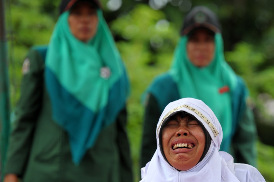 A Muslim girl cries out as she gets cane