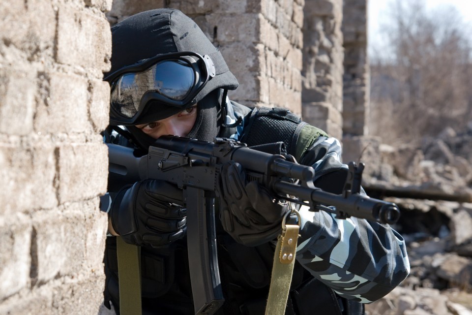 Soldier aiming a target with an automatic rifle