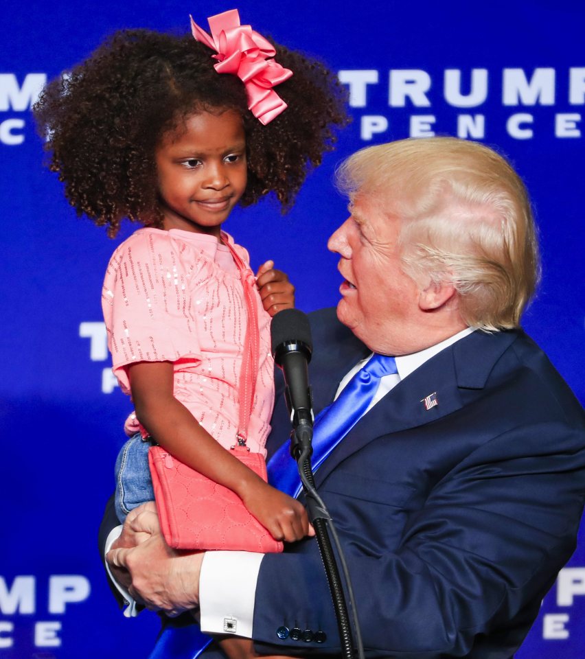 The little girl recoils from Trump as he moves in for a kiss on the cheek in Wisconsin last night