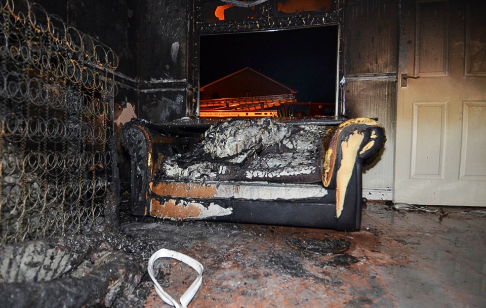  This sofa is completely destroyed and sits next to a ravaged mattress and blackened walls