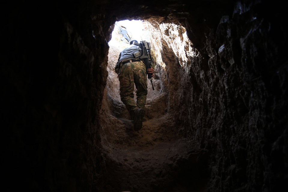 Pit of terror... A peshmerga fighter walks through an ISIS tunnel 