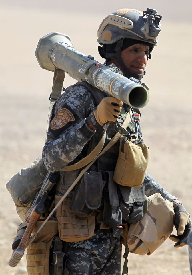 Another soldier, armed with a RPG launcher, makes his way through the town