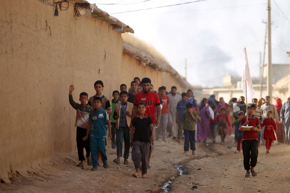 A group of child walk through the village after being freed from their ISIS occupiers