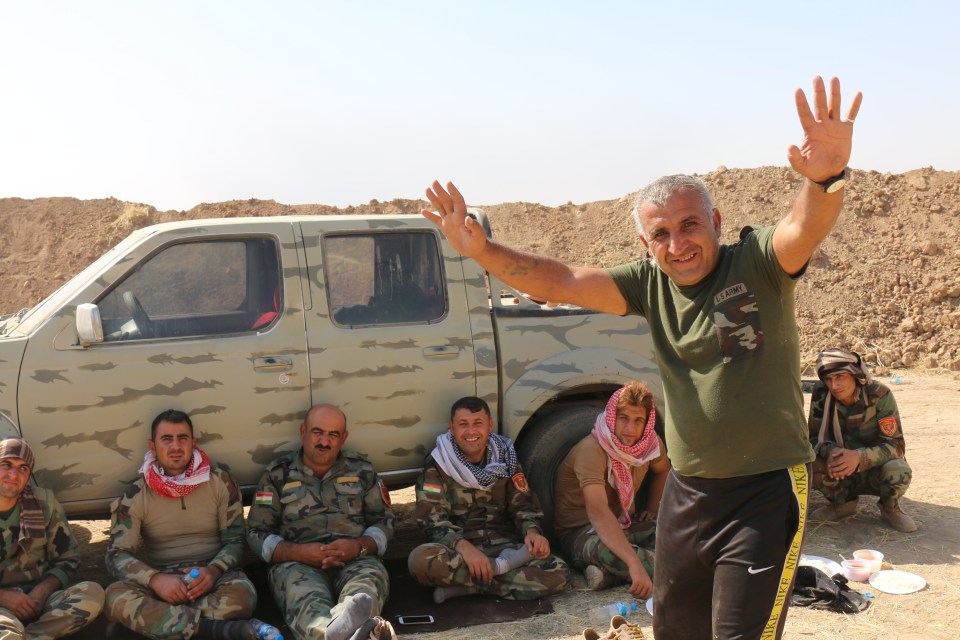 The Kurdish liberators rest next to one of their trucks