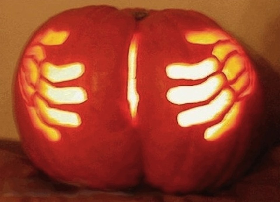 This pumpkin looks like a bum that is being grabbed by two hands 