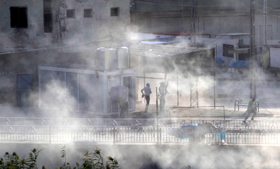  Smoke rises as Kurdish forces take up position at a site of an attack by IS jihads