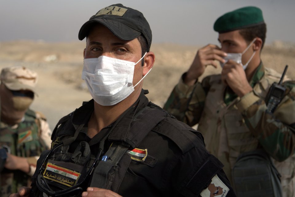  Iraqi troops wear masks to protect themselves from sulphur smoke from fires lit by Islamic State militants at oil wells and a sulfur plant fills the air