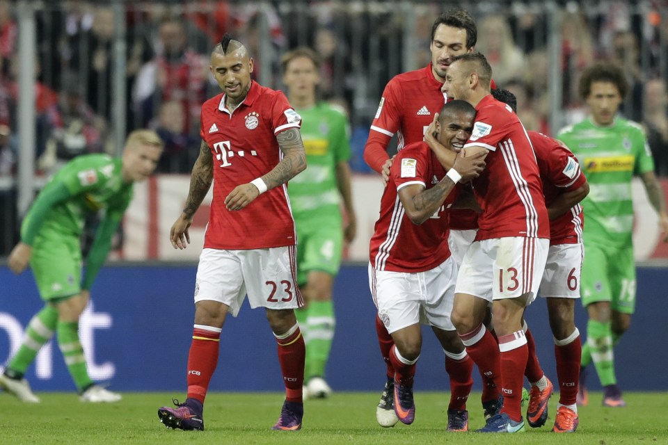  Douglas Costa is mobbed by his Bayern team-mates after scoring his side's second goal against Monchengladbach