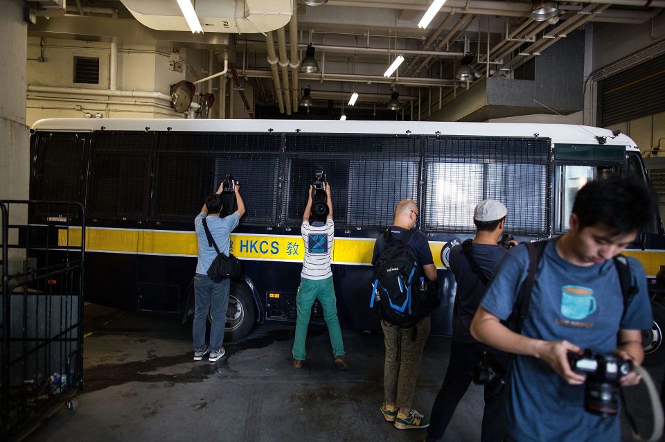  Photographers try to snap pictures of Jutting through the van's windows as it leaves court yesterday