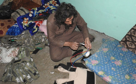  An older ISIS thug prepares a bomb