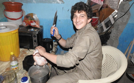  Preparing dinner... The boy grins as he cuts up a chicken