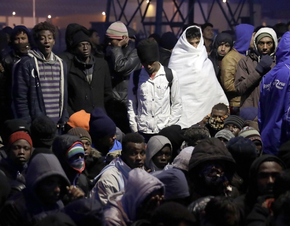 Migrants line-up to register at a processing centre in the makeshift migrant camp