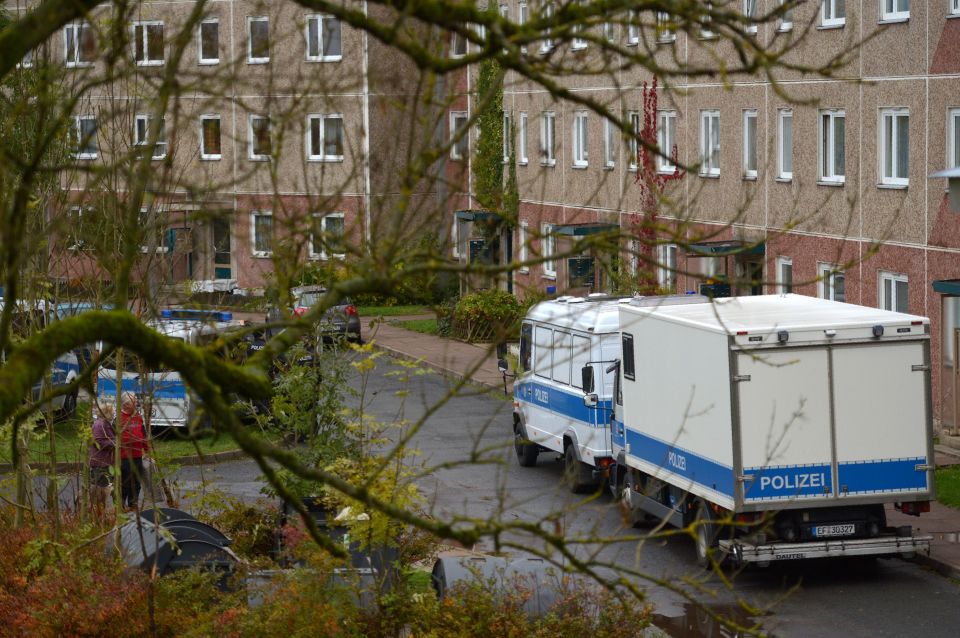  Police vehicles stand in front of a house in Jena, east Germany