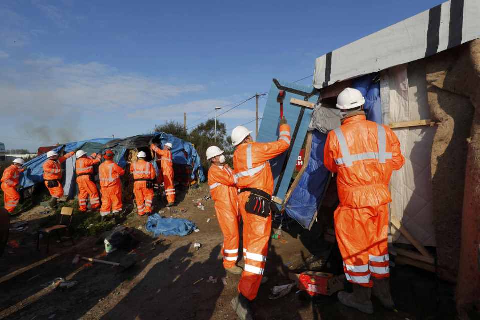 Demolition ... Workmen tear down a makeshift shelter at the Jungle camp