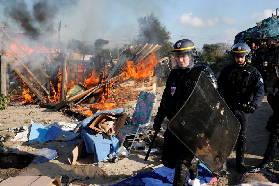 Riot police were on hand to protect demolition crews as migrants set fire to some buildings