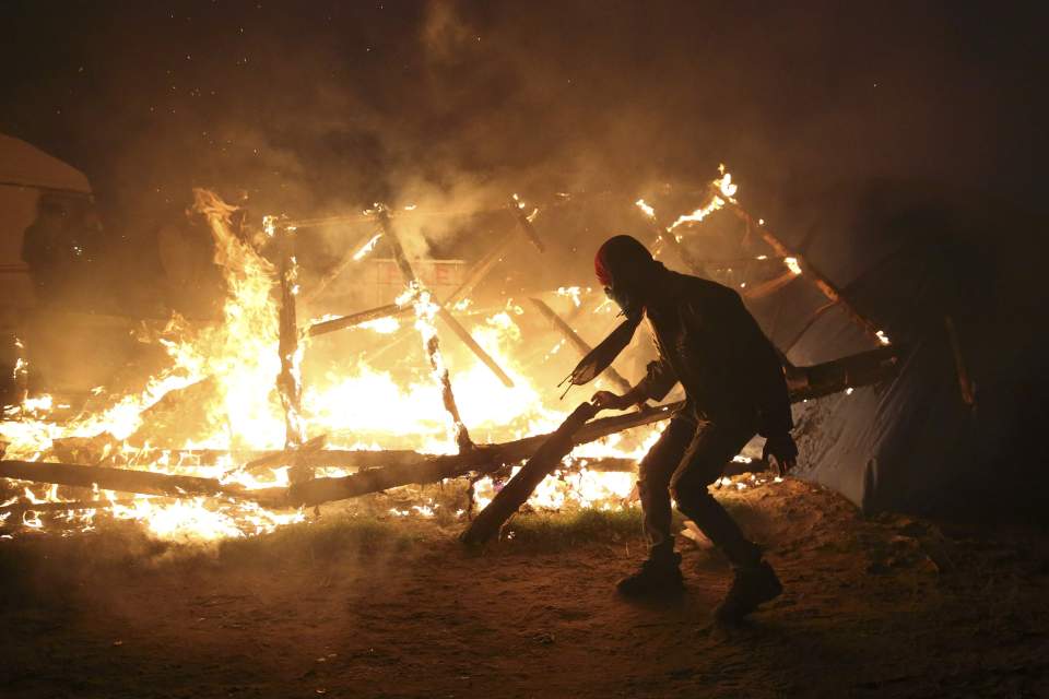 A rickety building collapses in flames