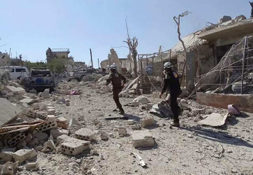  The Syrian Civil Defense group known as the White Helmets, run through the damaged buildings after airstrikes in the village of Hass