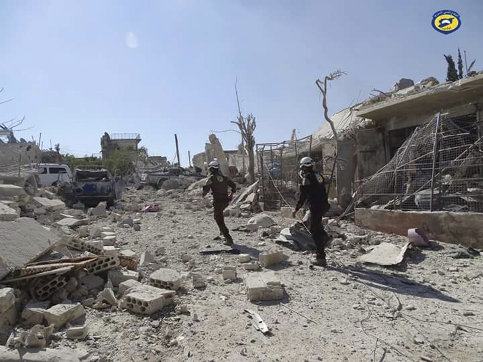  The Syrian Civil Defense group known as the White Helmets, run through the damaged buildings after airstrikes in the village of Hass