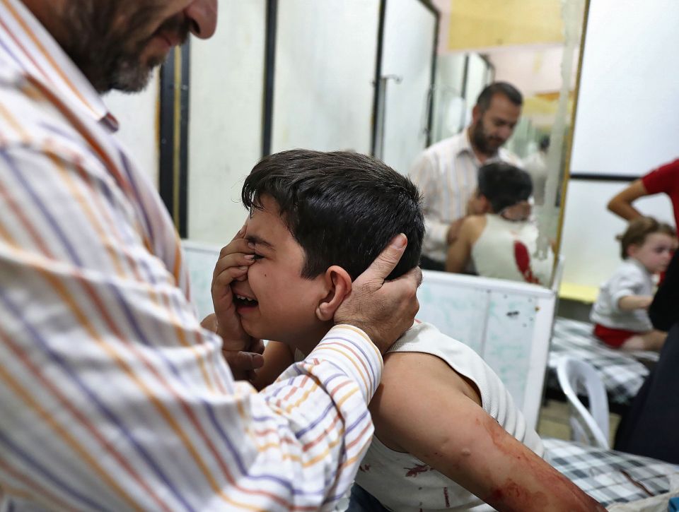  A distraught and wounded child being treated in a makeshift hospital in Douma