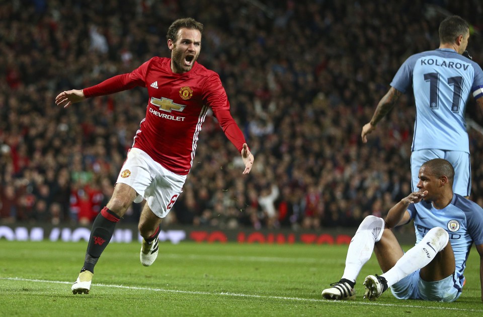 Manchester United's Juan Mata, left, celebrates scoring a goal during the English League Cup soccer match between Manchester United and Manchester City at Old Trafford stadium in Manchester