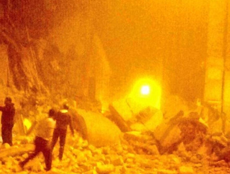  Rescue workers search through the destruction