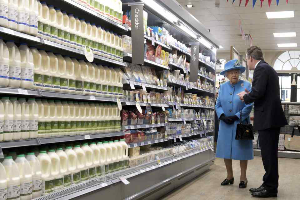 Britain's Queen Elizabeth talks with Waitrose Marketing Director Rupert Thomas as she looks around a Waitrose supermarket during a visit to the town of Poundbury