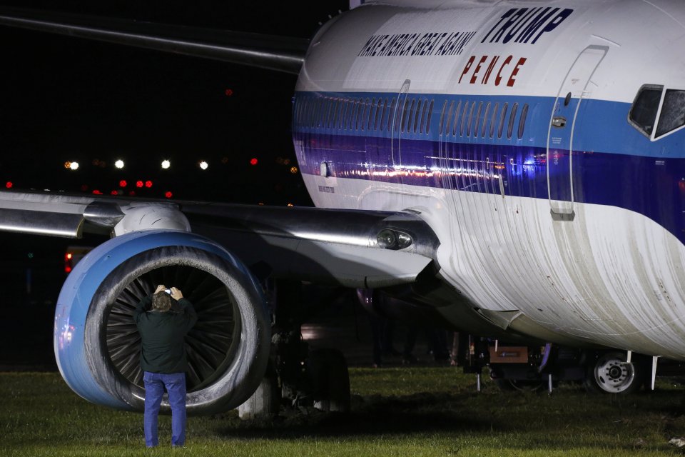 A man takes photographs as he inspects the plane's engine