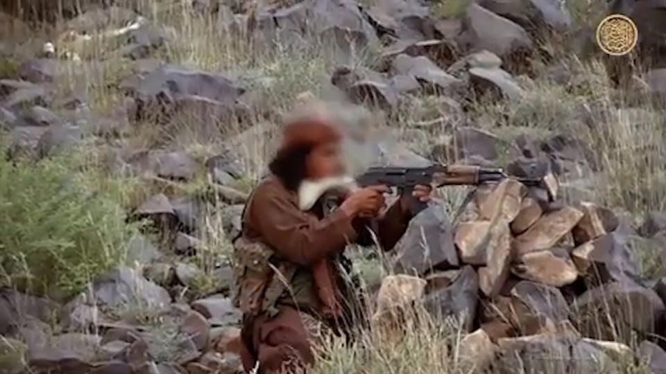  An Al-Qaeda fighter fires an assault rifle during a battle filmed for the group's media arm