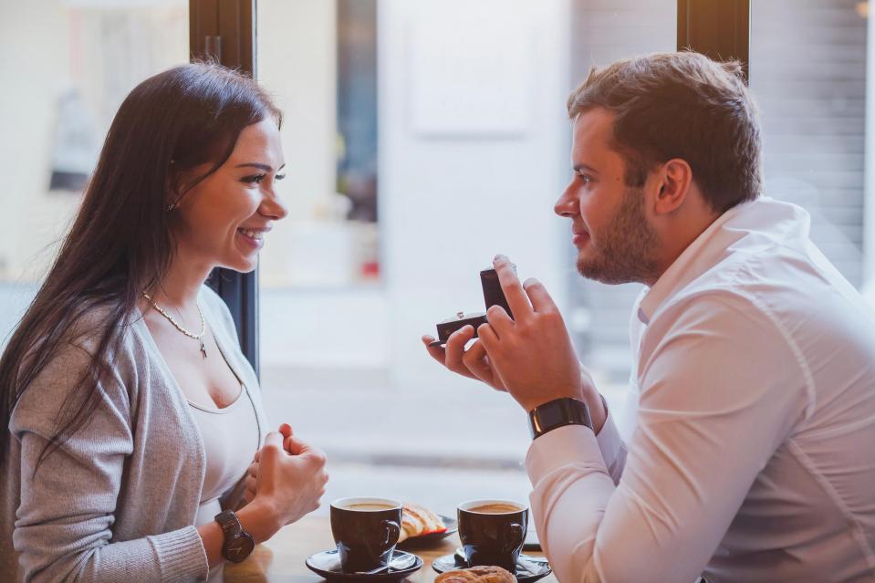 proposal, engagement concept, happy couple in restaurant, man offers the ring, marry me