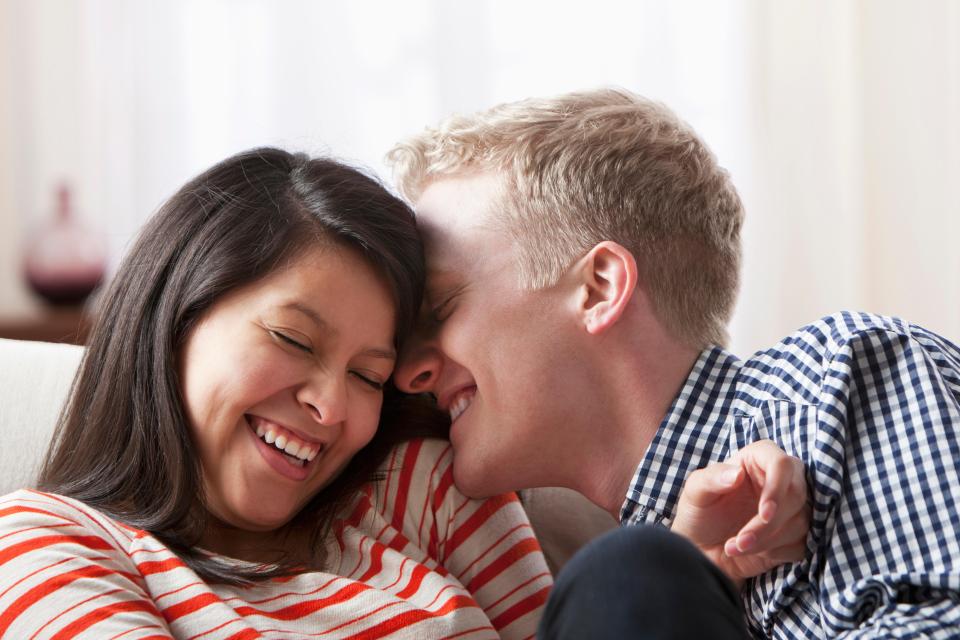 Smiling couple playing on sofa