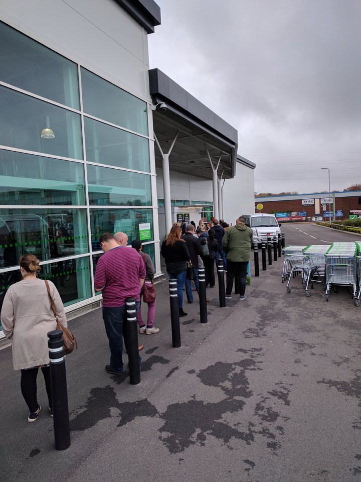  Shoppers outside ASDA in Trafford Park queuing up to use a cash machine