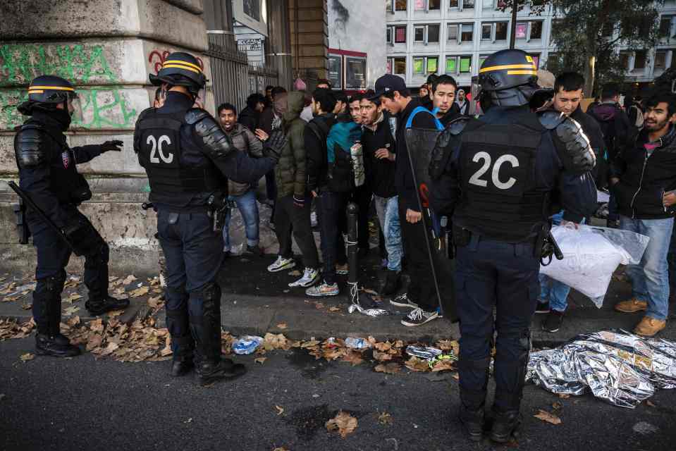  French riot policemen restrain migrants from returning to their tents