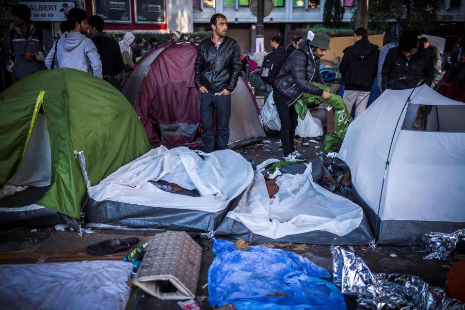  Migrants stand between tents at Boulevard de la Villette, near Stalingrad metro