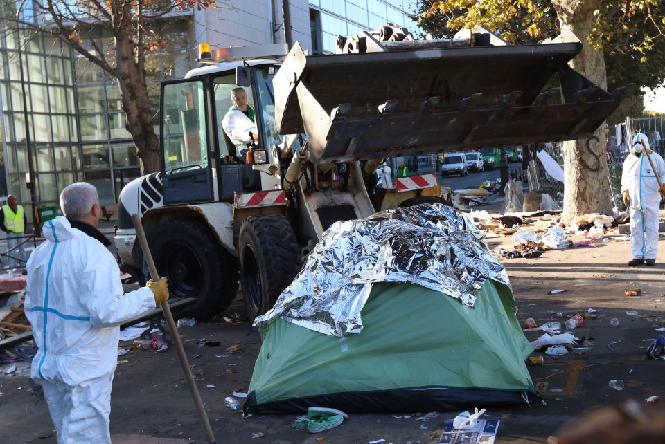  A bulldozer clears away tents and mattresses from the street in Paris