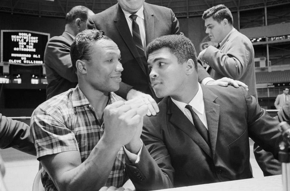 (Original Caption) Challenger Cleveland Williams (left) and titleholder Cassius Clay compare their big guns after signing to battle for the world heavyweight championship in the Houston Astrodome, November 14th. The defense will be Clay's fifth this year and sixth since he knocked out Floyd Patterson in Las Vegas last November 22nd.