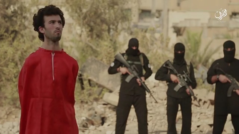  The footage starts with the prisoner facing away from a line of heavily armed ISIS thugs