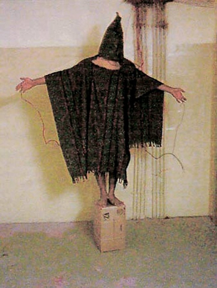 A hooded and wired Iraqi prisoner at Abu Ghraib prison