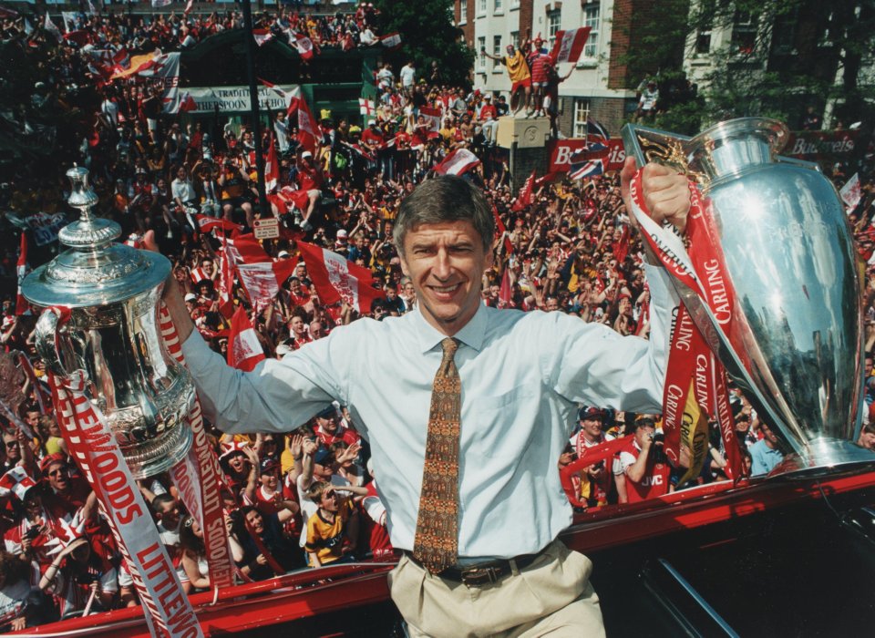 Arsenal manager Arsene Wenger shows off the FA Cup and FA Carling Premiership trophy to happy fans outside Islington Town Hall during celebrations for Arsenal's Double success.