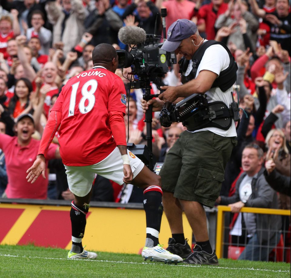 Man Utd's Ashley Young celebrates with a cameraman on a truly dark day for Wenger