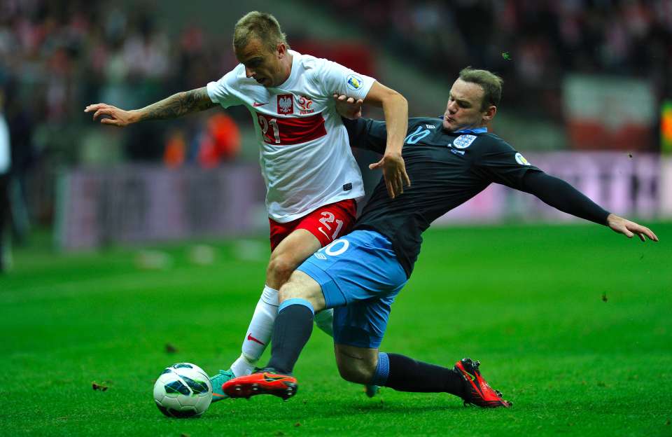 Kamil Grosicki fights for the ball with Wayne Rooney